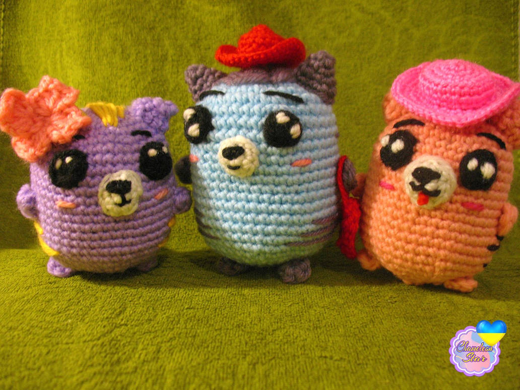A photo of handmade crochet amigurumi lilac cat named Tara, a light blue cat named Delaney and a pink cat called Aisling, who are a part of a big Tororo Puss family