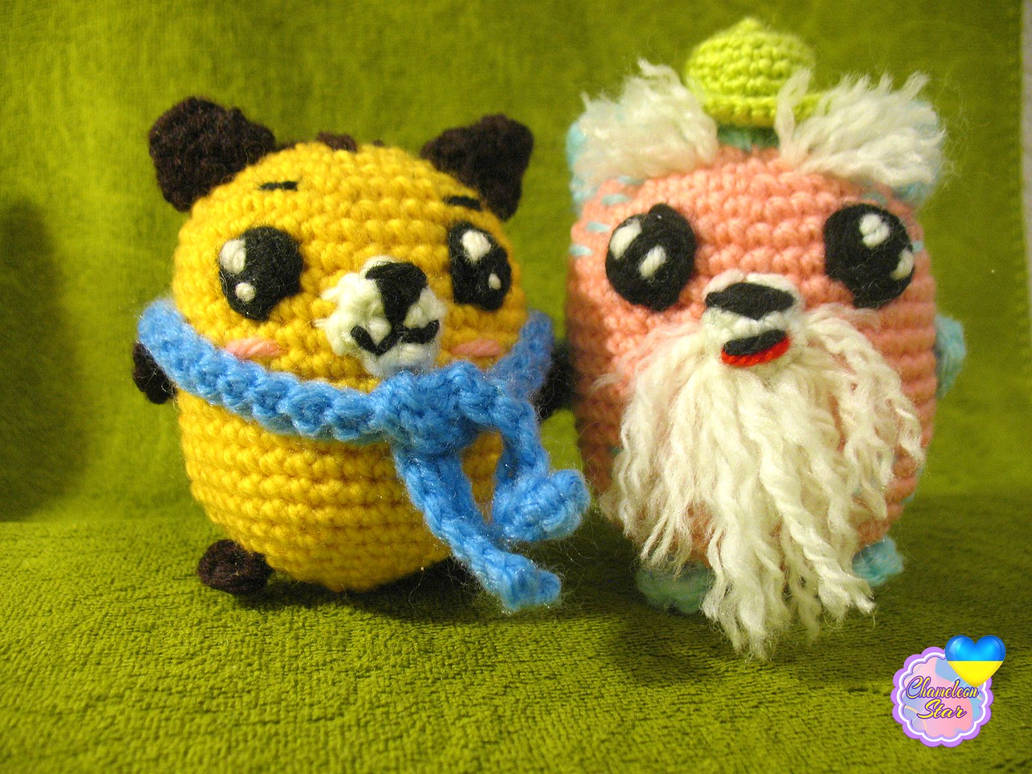 A photo of handmade crochet amigurumi yellow cat named Nolan and a pink cat called Donnagan, who are a part of a big Tororo Puss family