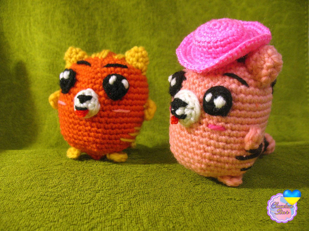 A photo of handmade crochet amigurumi orange cat named Finley and a pink cat called Aisling, who are a part of a big Tororo Puss family