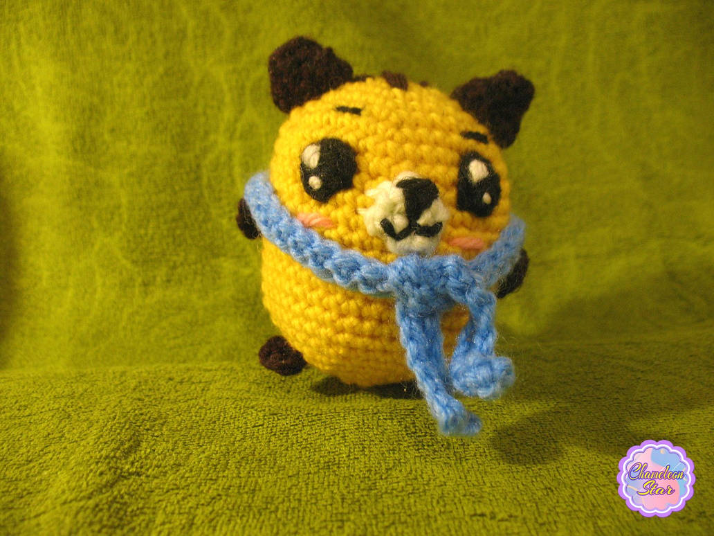 A photo of handmade crochet amigurumi yellow cat named Nolan, who is a part of a big Tororo Puss family