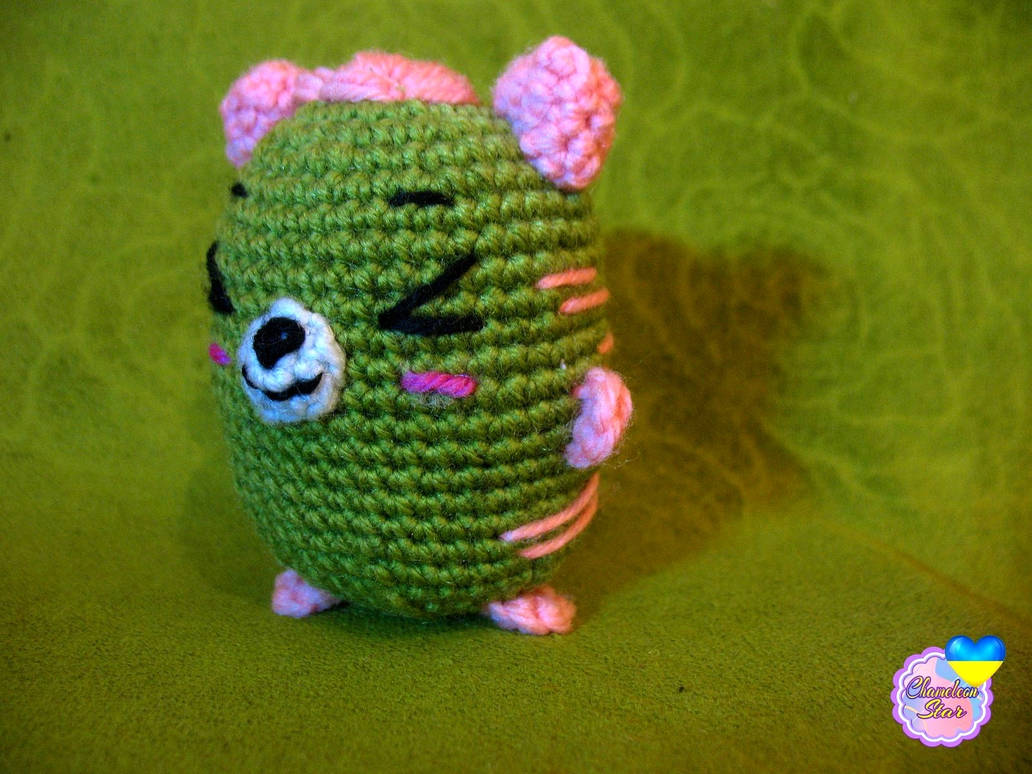 A photo of handmade crochet amigurumi pink cat called Donnagan, who are a part of a big Tororo Puss family