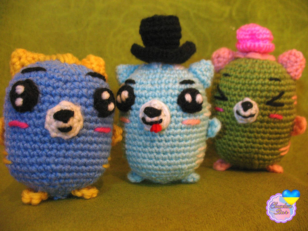 A photo of handmade crochet amigurumi blue cat named Quillan, a turquoise cat named Arlen and a green cat called Mannix, who are a part of a big Tororo Puss family