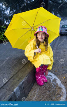 Young caucasian girl playing in the rain