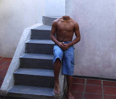 Barefoot boy sitting on edge of staircase