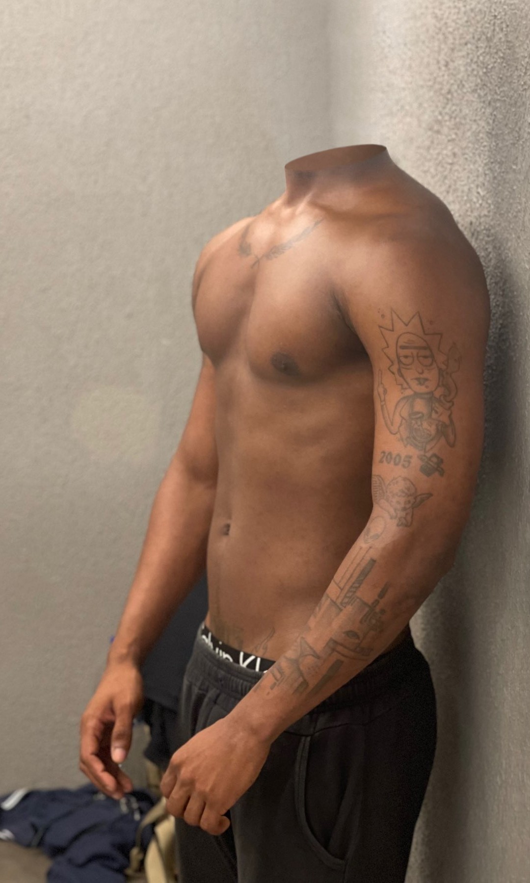 Smooth male torso and tattooed arm