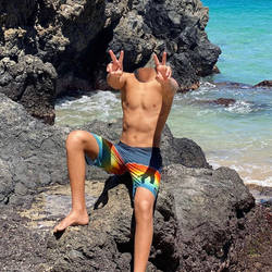 Headless boy on beach rocks on a sunny day