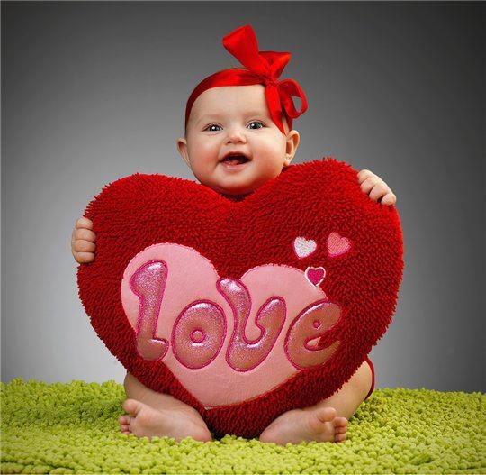 Baby holding a love heart plush for Valentines Day