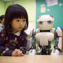 Student girl with a robot in classroom