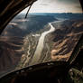 Fighter aircraft flying over canyon and river