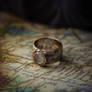 Traveler's jewelry compass ring, lying on a map