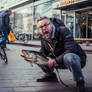 Screaming man with a fish on asphalt road