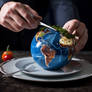 Cutting planet Earth cake on a plate