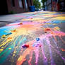 Different colours splattered on asphalt