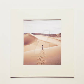 Person walking alone in sand desert. Framed photo