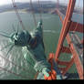 Statue of liberty climbing Golden Gate bridge