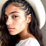 Jessie Reyez wearing a white hat.