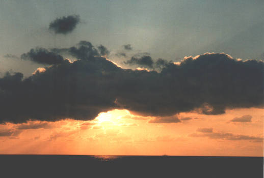 Sun behind clouds at sea 1988