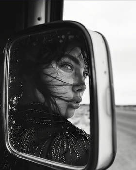 Beautiful girl reflected in the rearview mirror