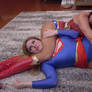 Supergirl is strangled by Wonder Woman's legs