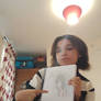 Me IRL with my drawing of one of my OCs