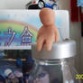 Clay man sitting on bottle