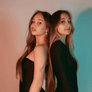 GIF: Twins stands back to back in black dresses