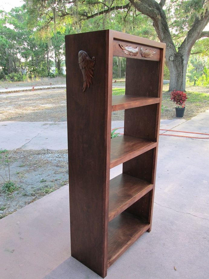 Bookshelf with carved wings.