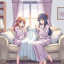 Two Girls On A Couch In Pajamas Sewing A Dress