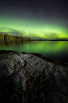 Northern lights glowing over lake by JuhaniViitanen