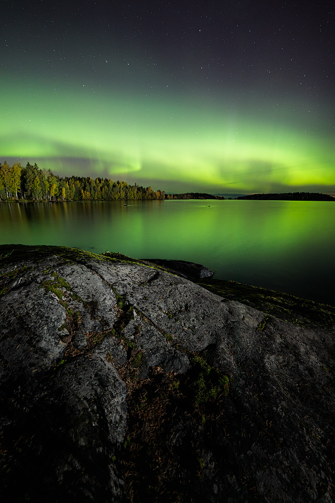 Northern lights glowing over lake