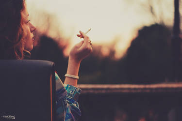 The lady smokes on a sunset balcony in Amsterdam