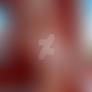 Nude woman with water droplets near window