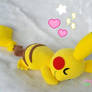 Cuddling Pikachu plushie