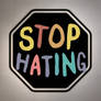 STOP HATING in colorful font in the shape of a s (