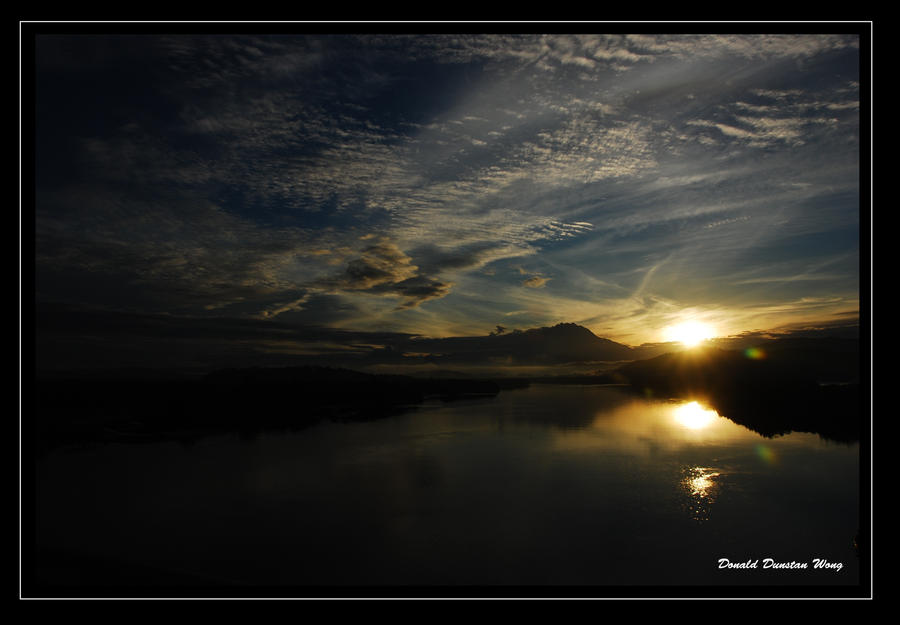 Sun rises behind Mt Kinabalu