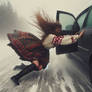 Woman holding a car door in a blizzard windy skirt