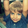 A happy little boy playing on a farm